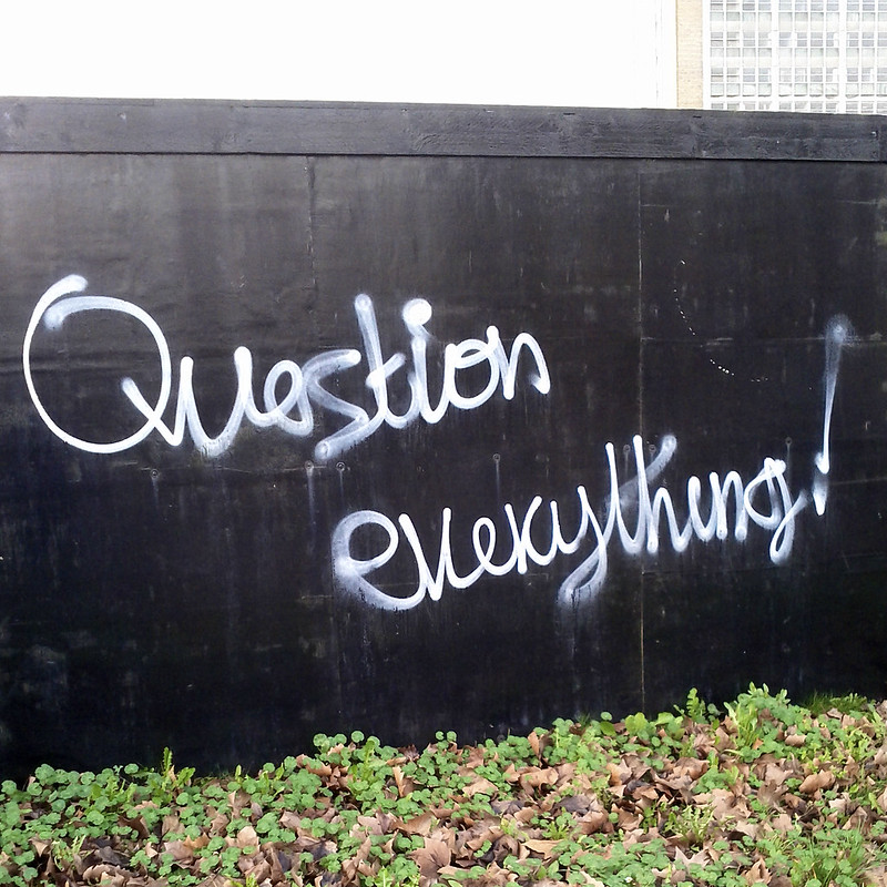 Question everything graffiti in white paint