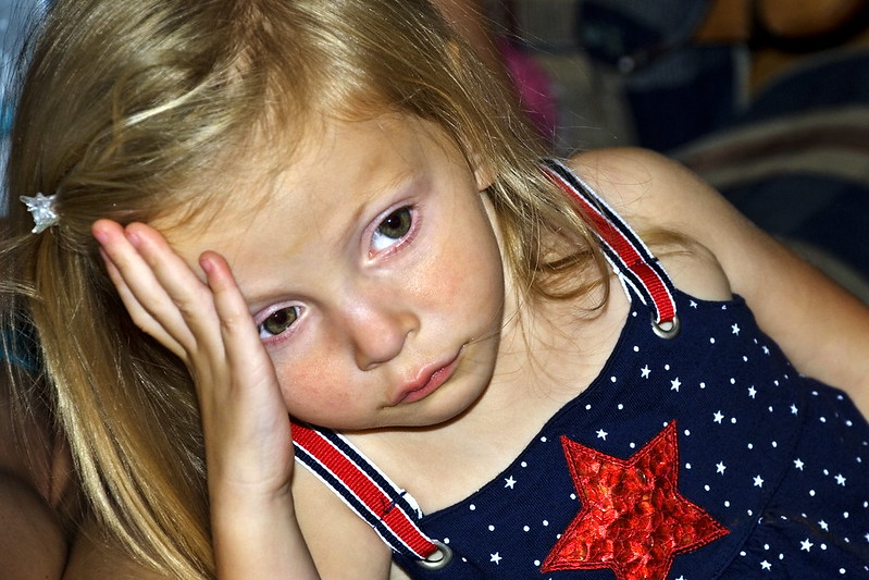Little girl with her hand on her forehead