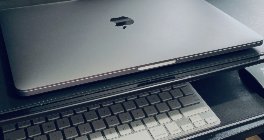 Laptop, keyboard, and mouse on desktop