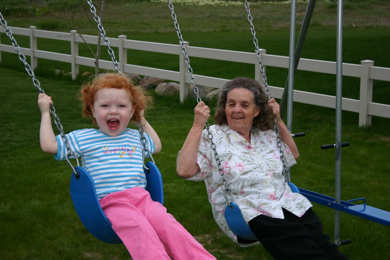 Grandma and granddaughter on the swings