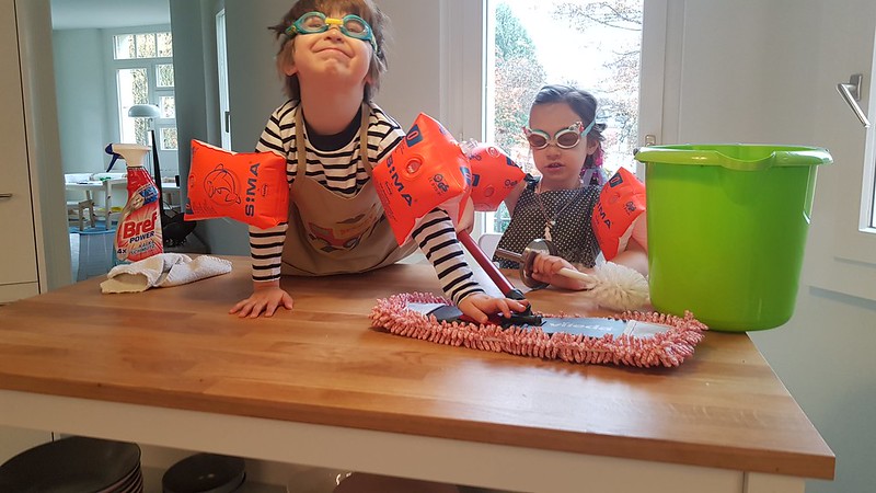 Boy and girl in the kitchen taking their job of cleaning very seriously
