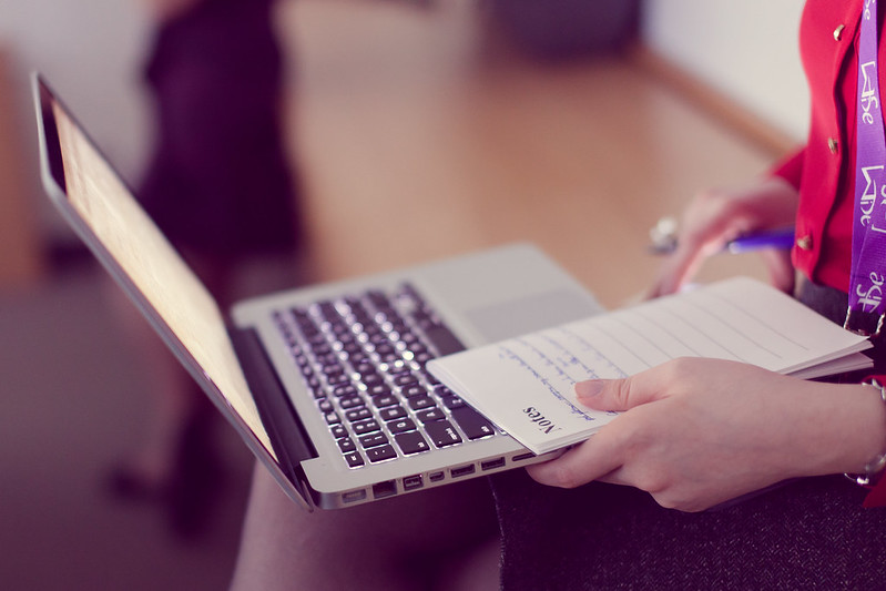 Taking notes on notepad and laptop