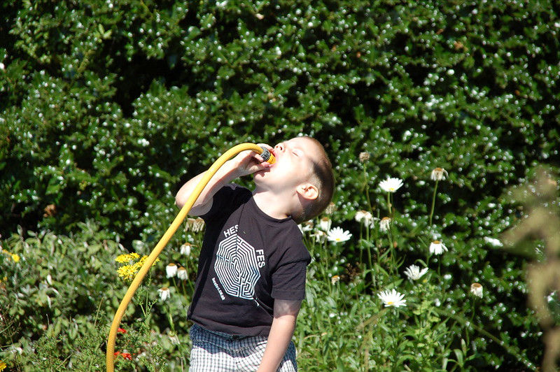 Child drinking out of the hose