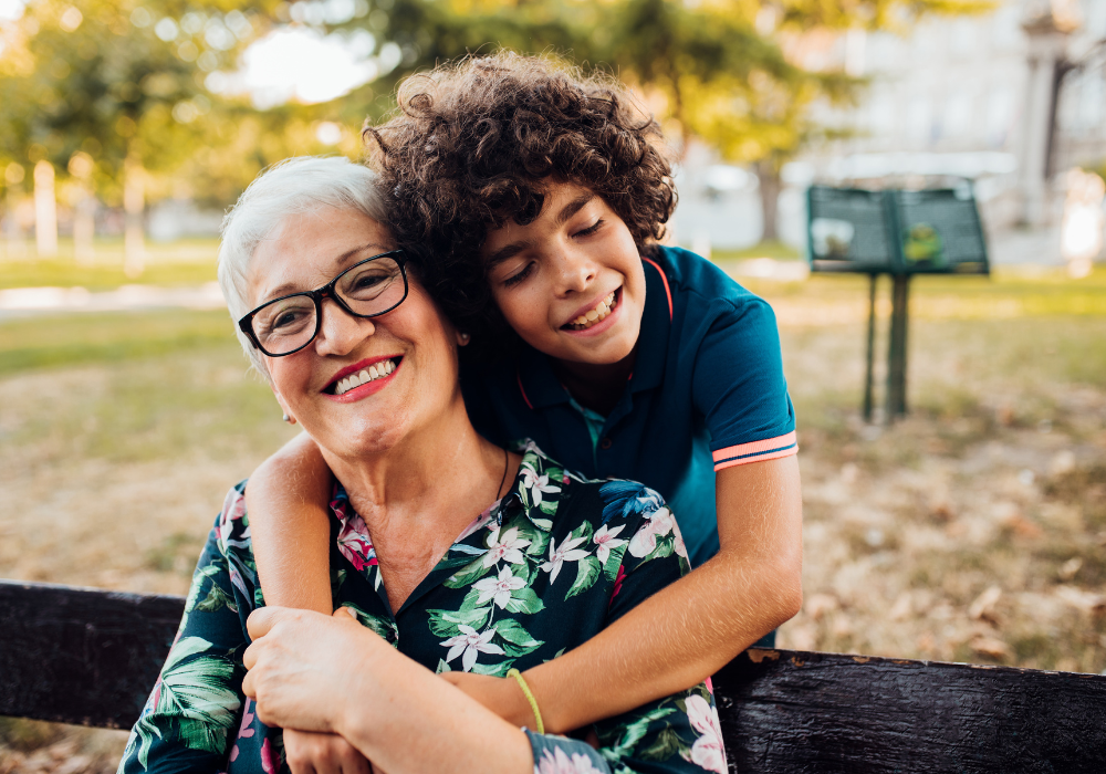 Grandma and kid smiling on park bench