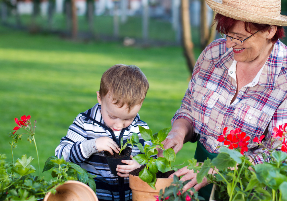 Child planting flowers with Grandma