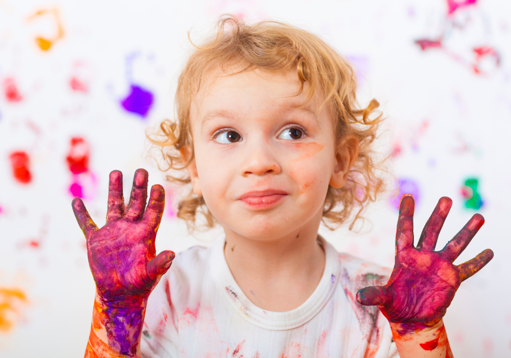 Child with paint all over hands