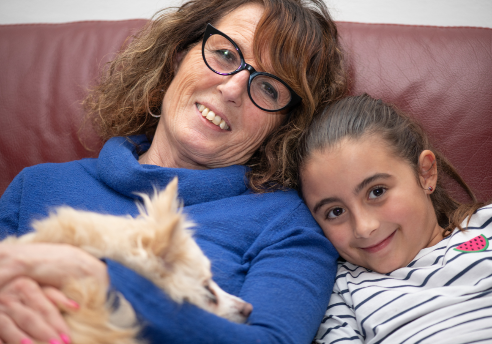 Grandma, granddaughter, and dog on the couch
